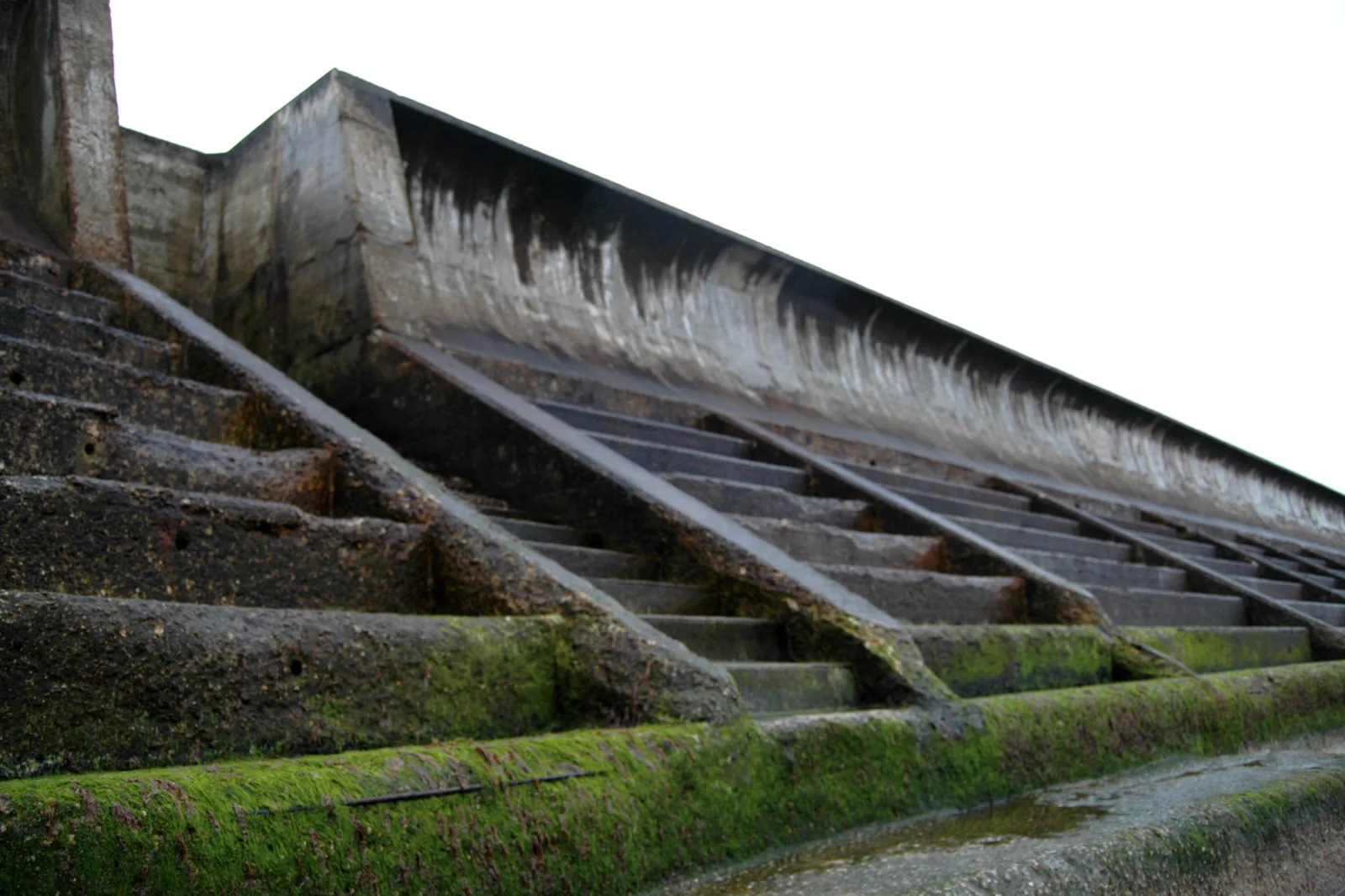 A large concrete flood defence revetment, engineered public infrastructure on the coast.