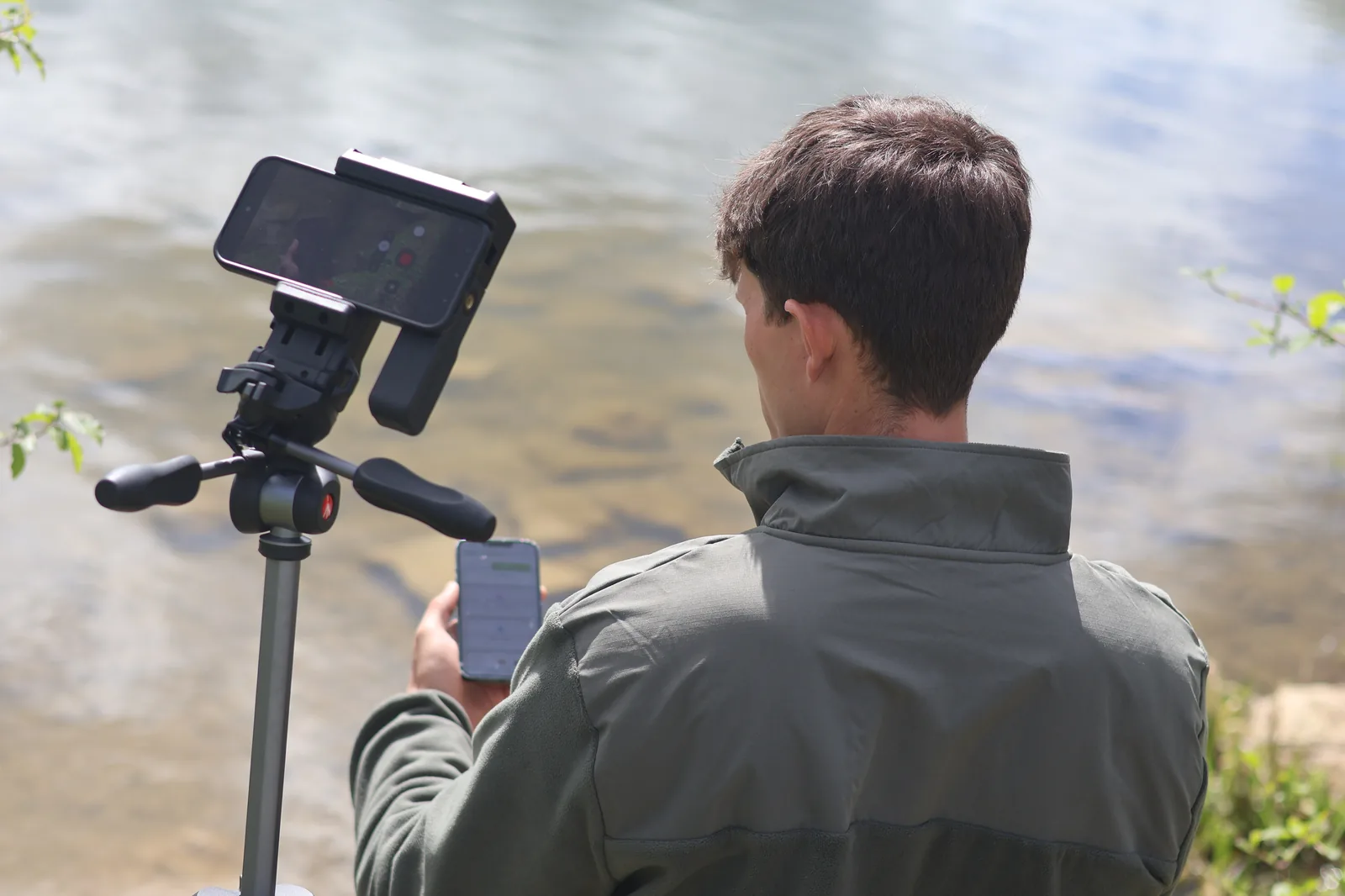 Volunteer recording a sighting at the waterside on a phone